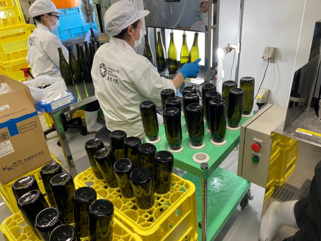 写真：瓶を洗って、そのわきでお酒を詰めているところ